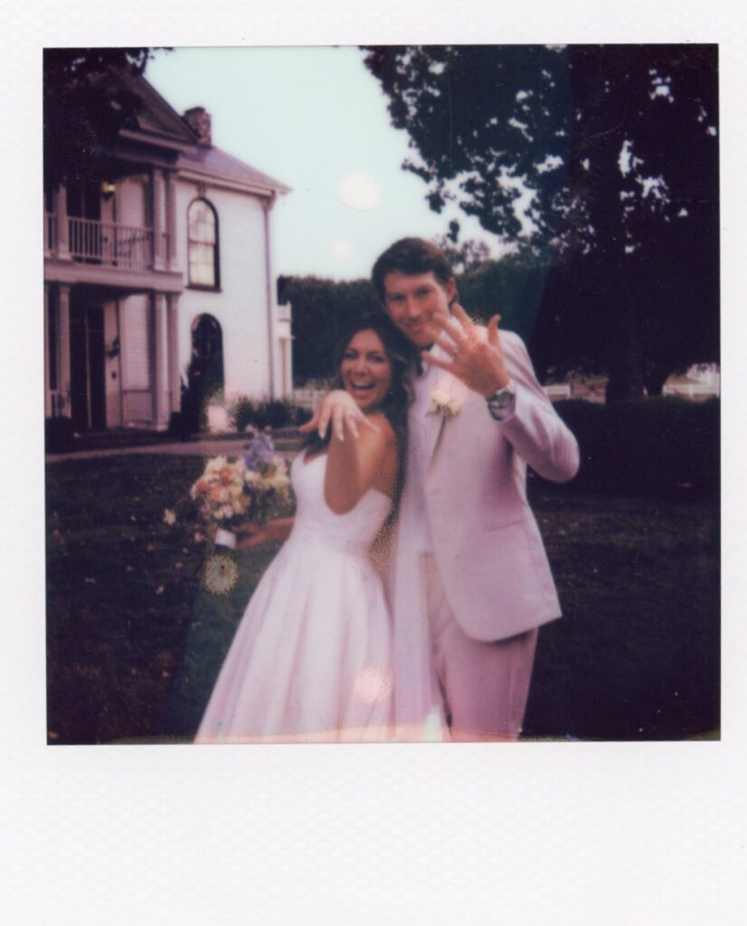bride and groom showing off their rings in front of their wedding reception venue in nashville