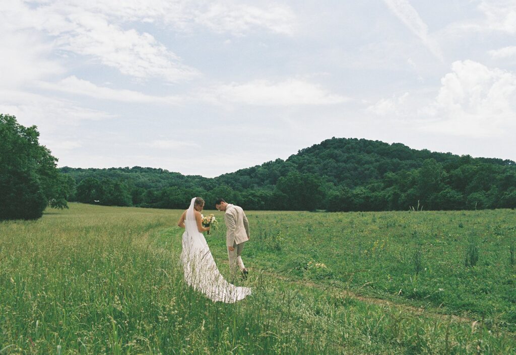 photo of couple walking in an open field at their nashville wedding venue, southall meadows