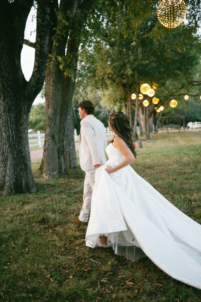 candid photo of a bride and groom, trees behind them at a nashville wedding venue