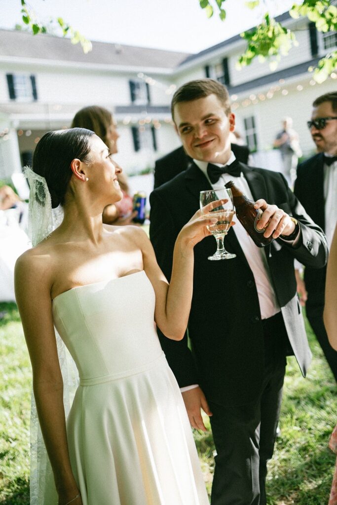 bride and groom toast with drinks during an outdoor reception captured by a Nashville TN wedding photographer.