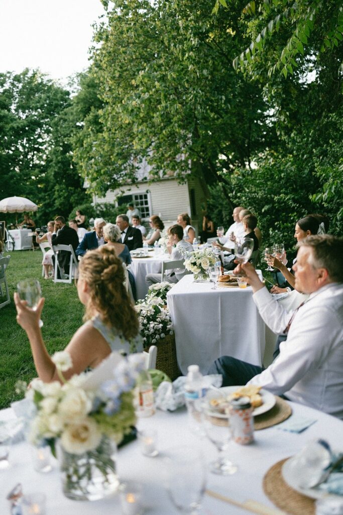 wedding guests raise glasses during an elegant backyard reception photographed by wedding photographers in Nashville TN.