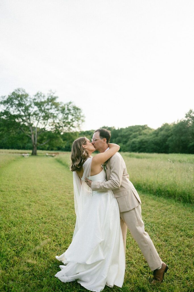 bride and groom sharing a romantic kiss in an open Tennessee field, photographed by a Nashville TN wedding photographer