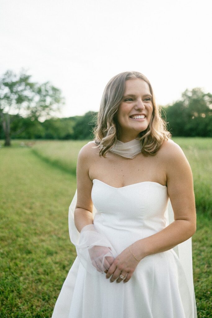 bride smiling in a strapless gown during golden hour portraits by wedding photographers in Nashville TN