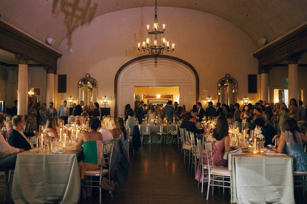 elegant candlelit wedding reception in Nashville Tennessee with guests seated at long tables inside a grand ballroom