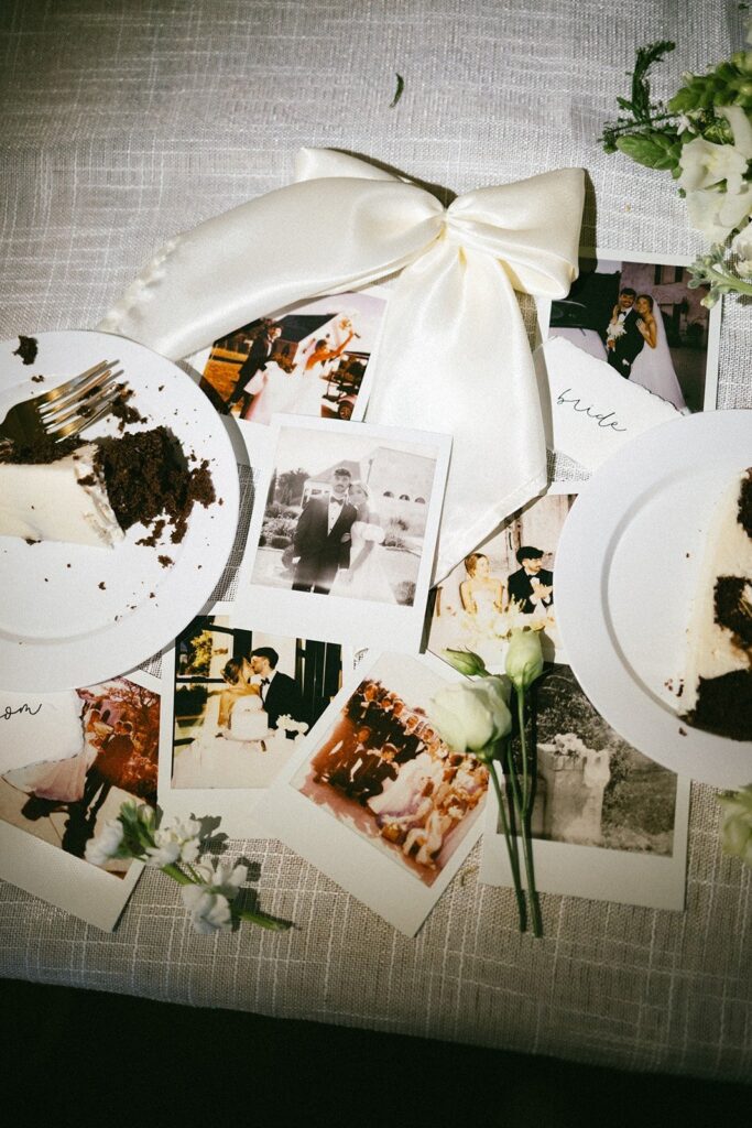 wedding cake slices and polaroid photos scattered on reception table at a nashville tennessee wedding