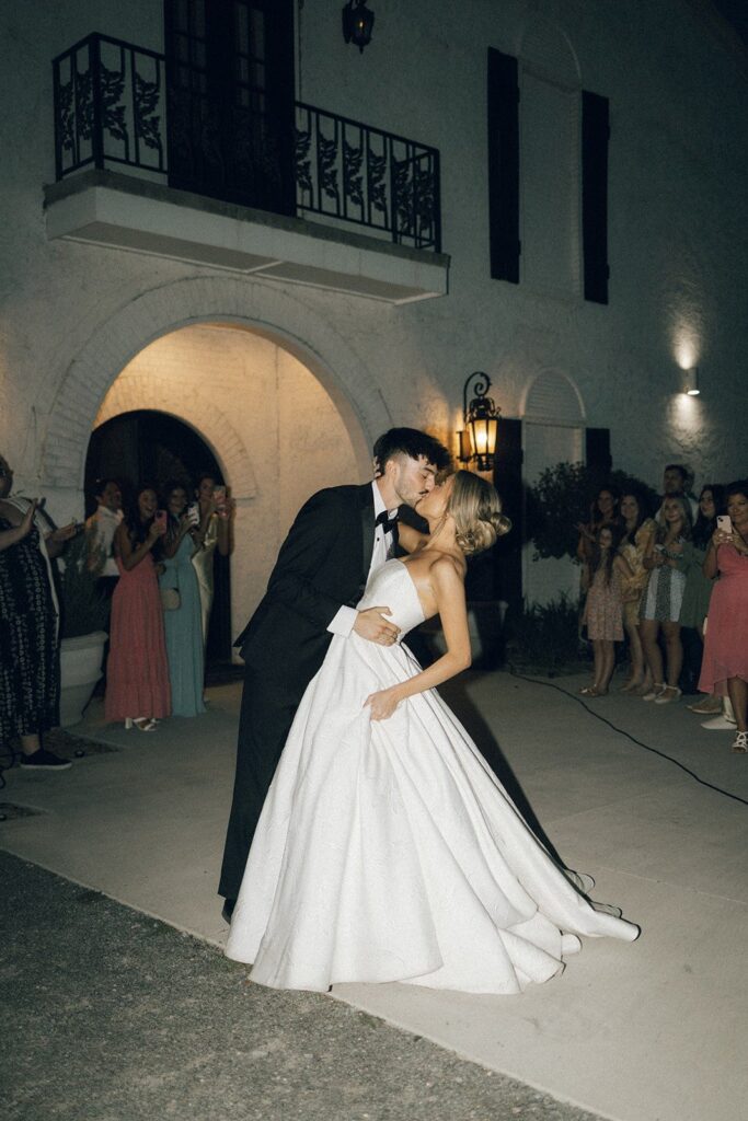 bride and groom sharing a romantic dip and kiss outside their venue at night in nashville tn