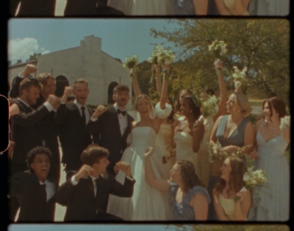 wedding party celebrating with bouquets raised in the air outside a Nashville TN wedding venue