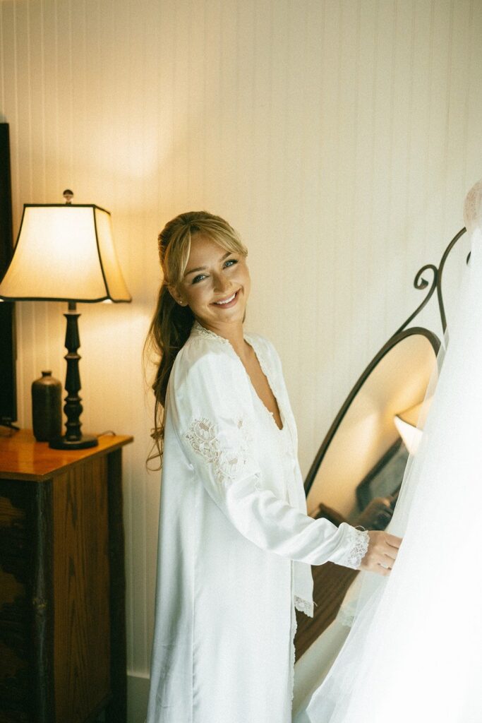 bride getting ready in a softly lit bedroom captured by a nashville tn wedding photographer specializing in timeless wedding photography