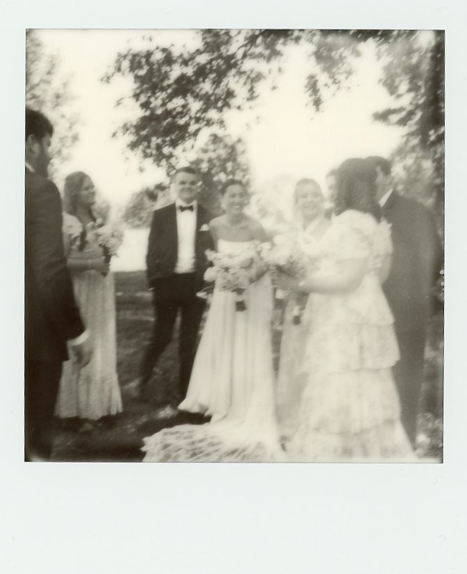 outdoor wedding ceremony moment with bride and groom holding bouquets in a soft, film-style image by Nashville wedding photographers