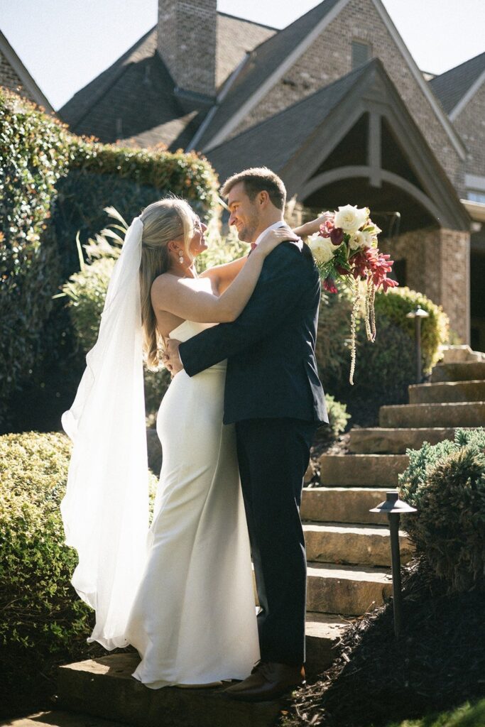 bride and groom sharing a romantic portrait on stone steps outside a classic estate, photographed by one of the top Nashville wedding photographers