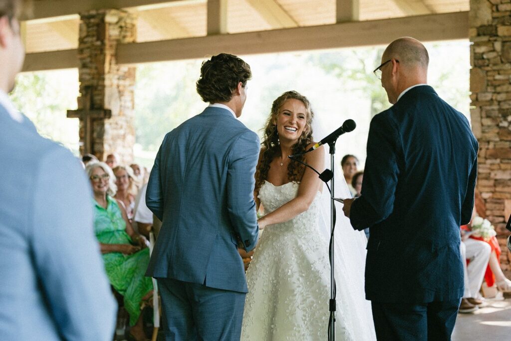 bride smiling during an outdoor wedding ceremony as she exchanges vows, photographed by one of the top Nashville wedding photographers