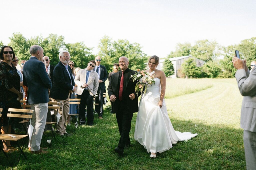 bride walking down the aisle with her father during an outdoor ceremony, photographed by a Nashville TN wedding photographer