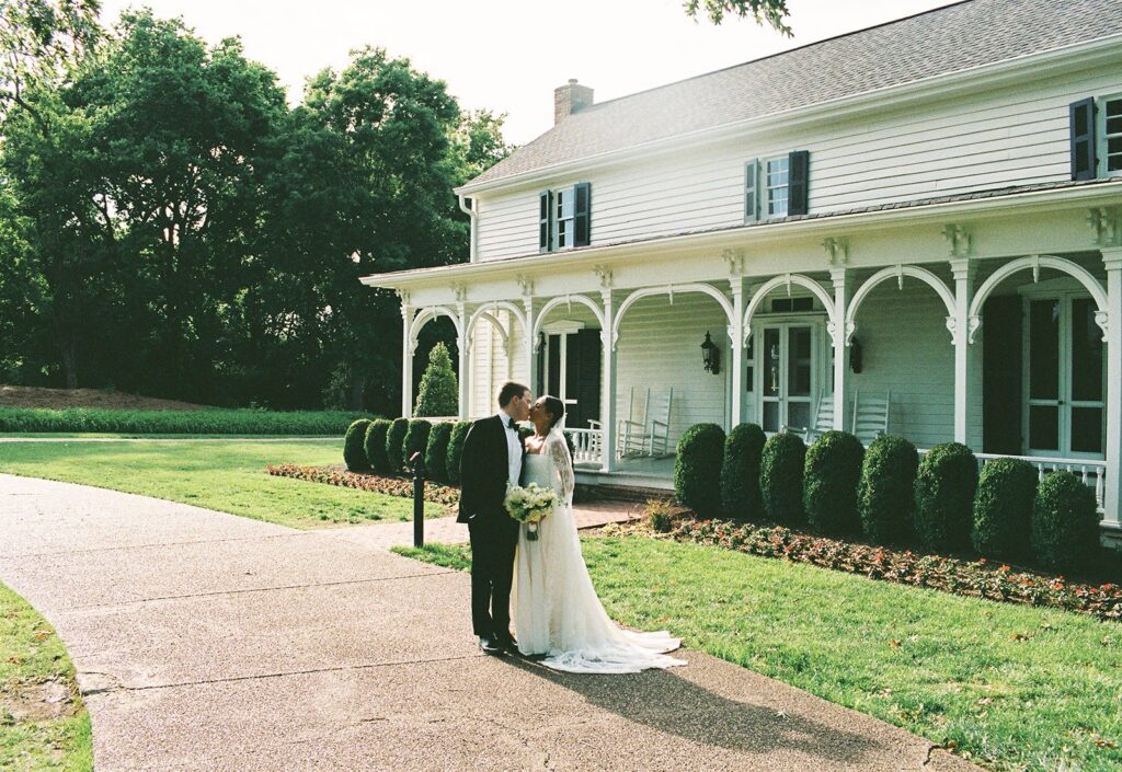 bride and groom sharing a kiss outside a historic Southern estate, beautifully captured by photographers in Nashville Tennessee