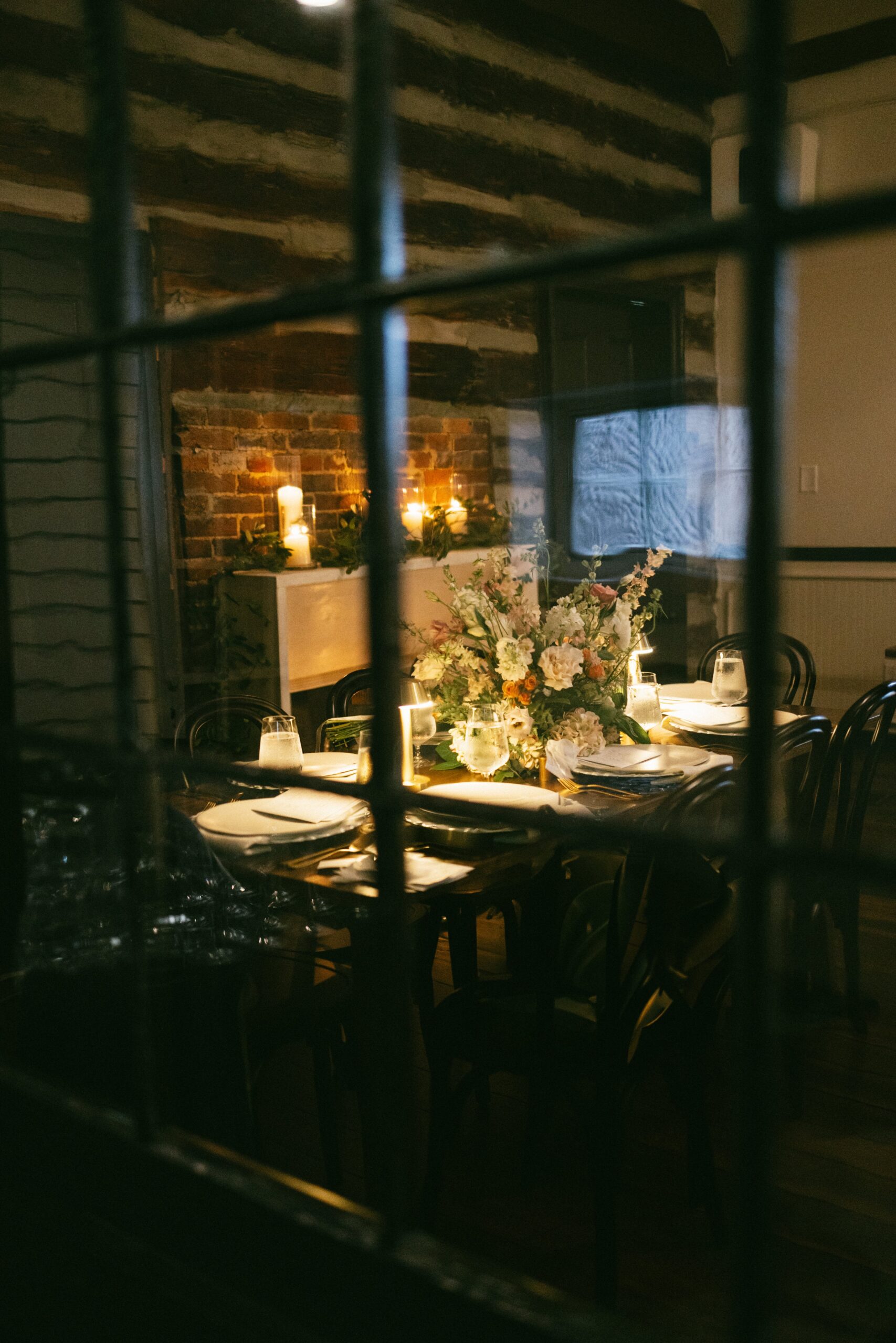 Candlelit reception table with floral centerpiece and warm lighting inside a rustic venue, representing the atmosphere of small wedding venues Nashville TN couples love.
