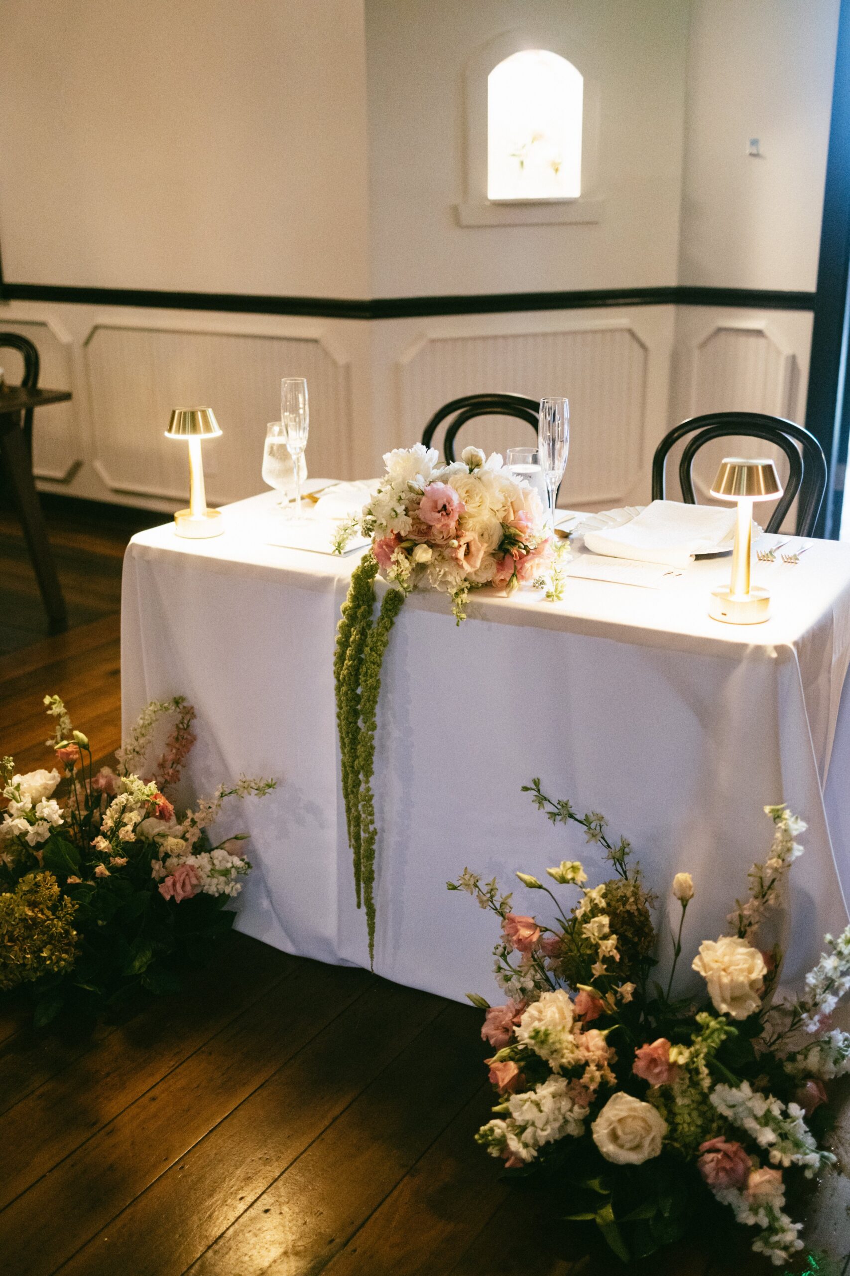 Romantic sweetheart table with candles and cascading floral arrangements set inside one of the most charming intimate wedding venues in Nashville TN.