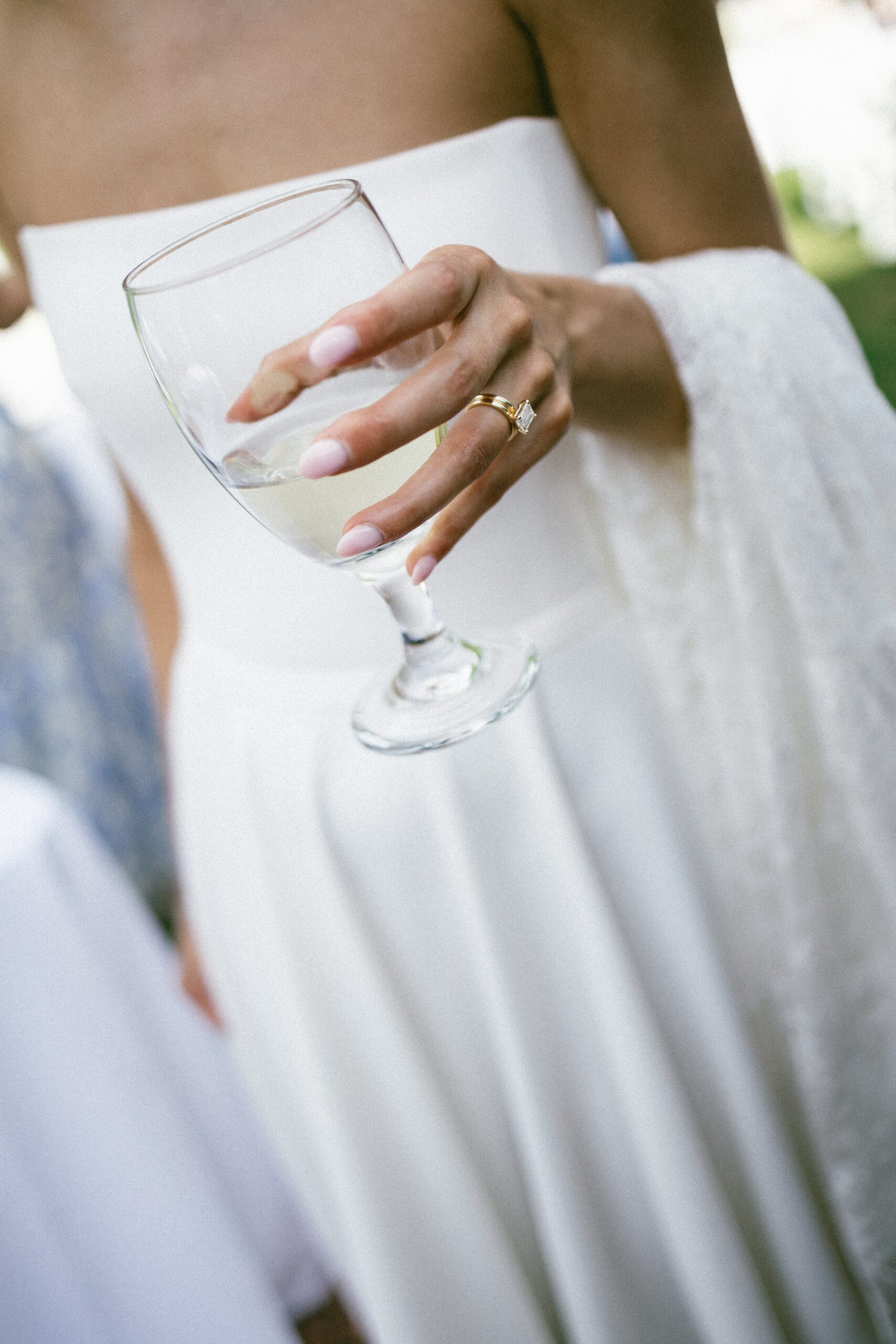 Bride holding a glass of white wine showing her engagement ring during a relaxed cocktail hour at one of the small wedding venues near Nashville TN.