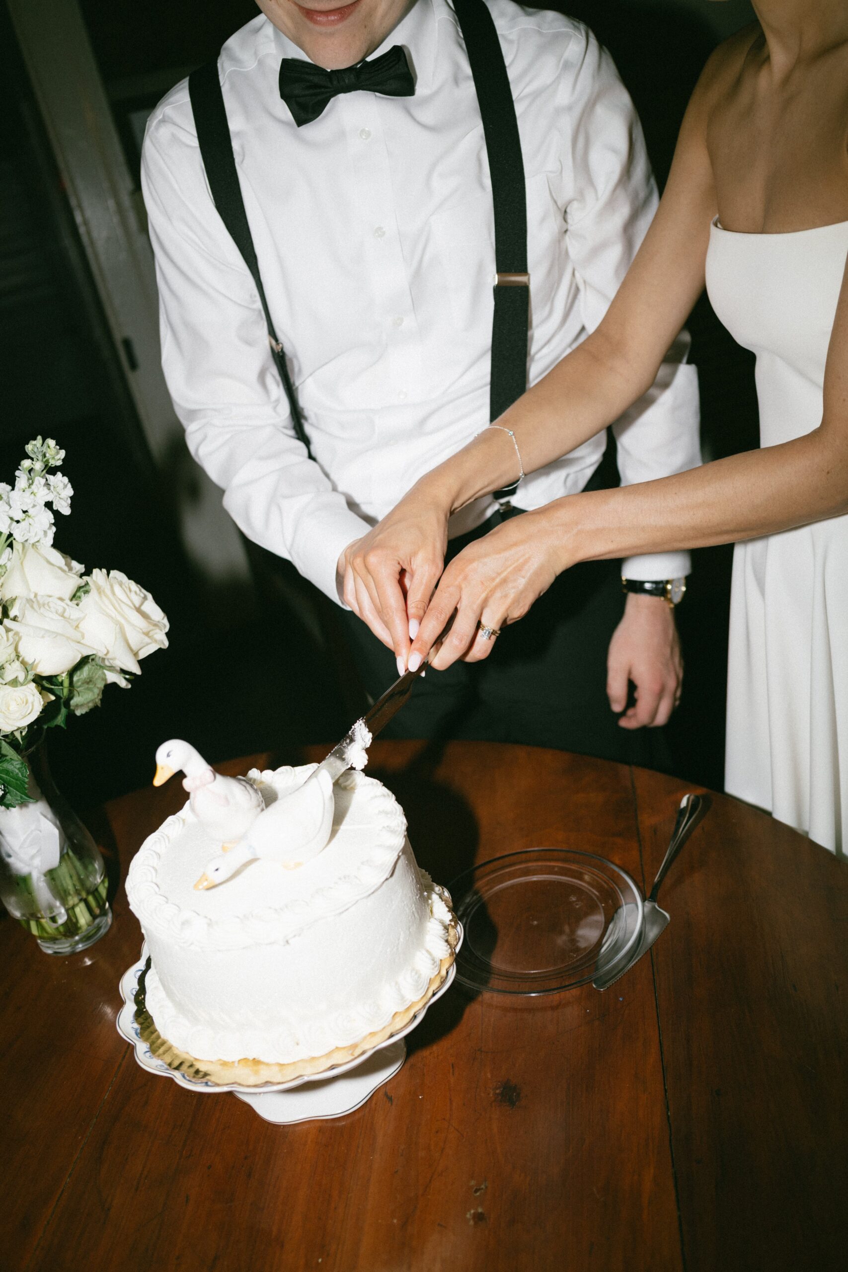 Bride and groom cutting a small white wedding cake during an intimate reception at one of the cozy small wedding venues in Nashville TN.