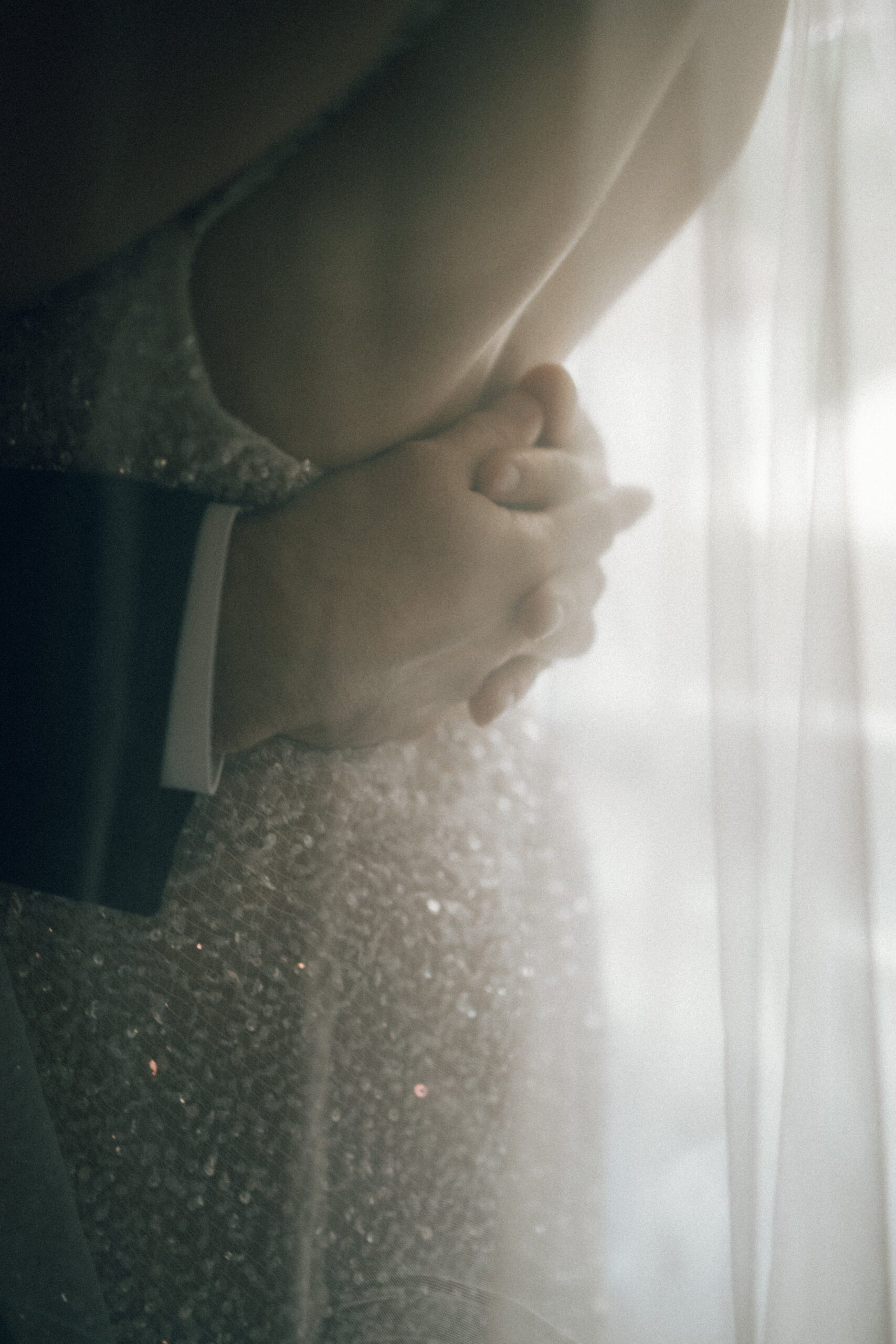 Close-up of groom holding the bride as they stand together in soft window light during a romantic moment at one of the small wedding chapels in Nashville TN.