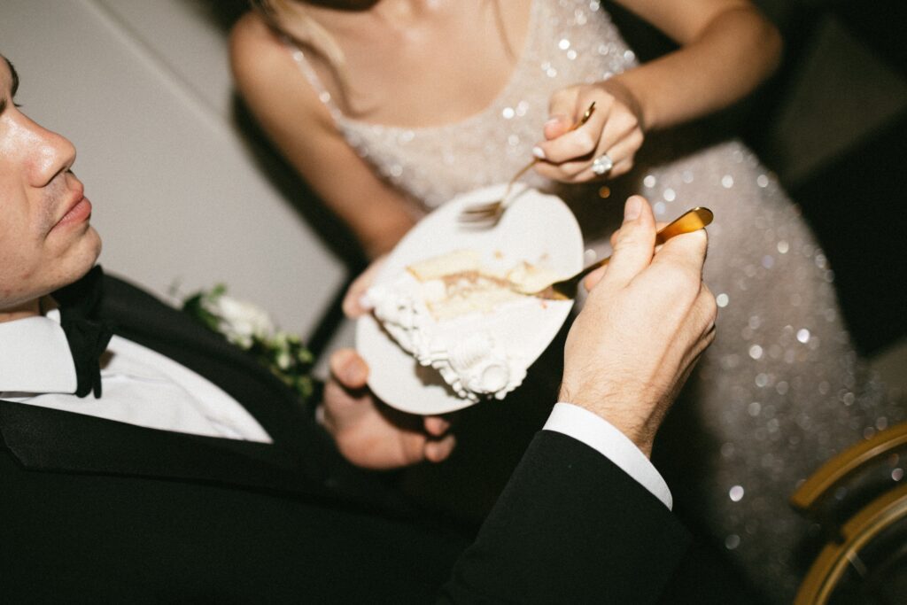 Bride and groom sharing bites of wedding cake during a romantic reception at a small wedding venue in Nashville TN.