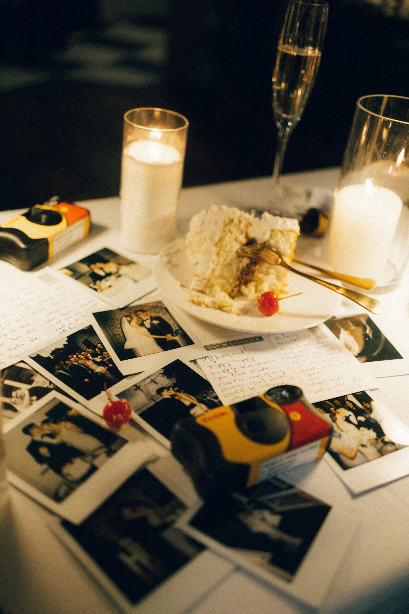 Candles, disposable cameras, and printed wedding photos styled on a reception table at a romantic small wedding venue in Nashville TN.