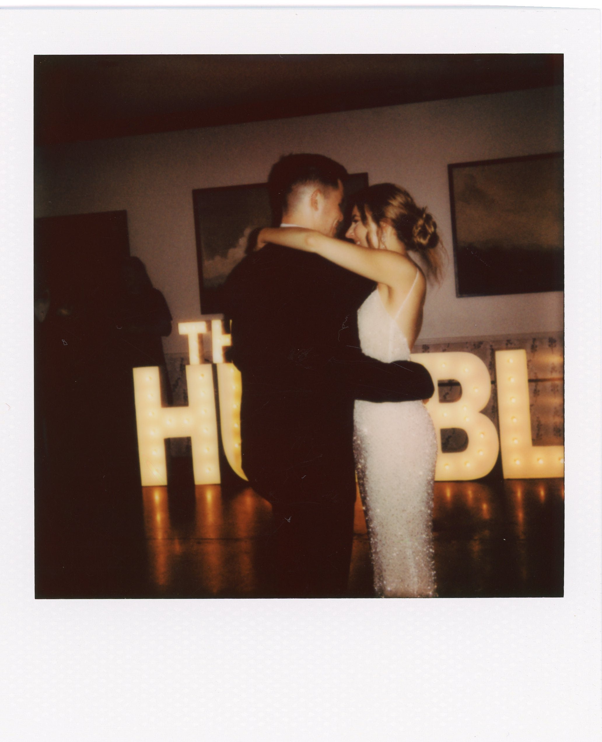 Bride and groom share their first dance in front of glowing marquee letters during a reception at one of the intimate wedding venues in Nashville TN.