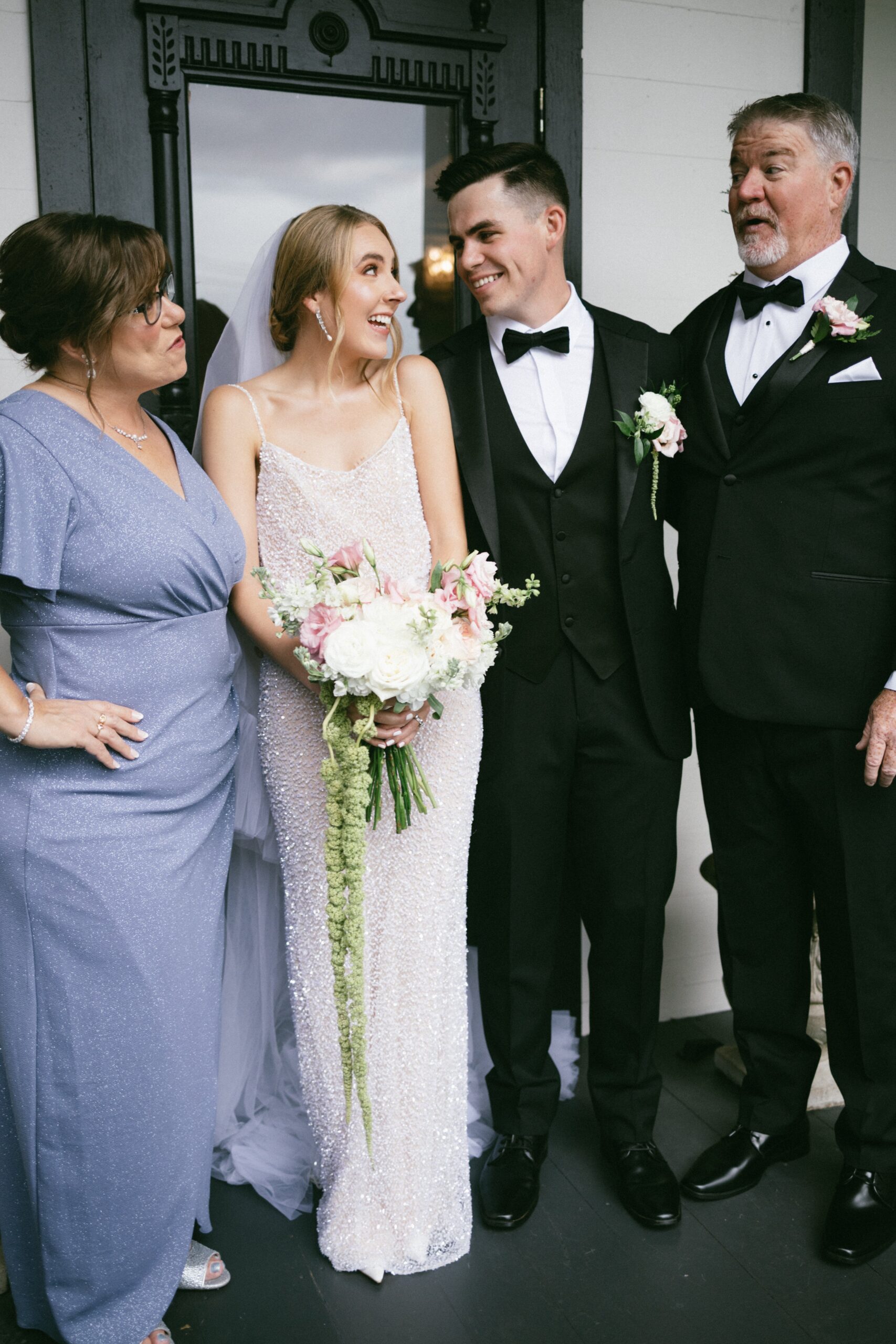 Bride and groom smiling with their parents outside an intimate wedding chapel in Nashville TN after the ceremony.