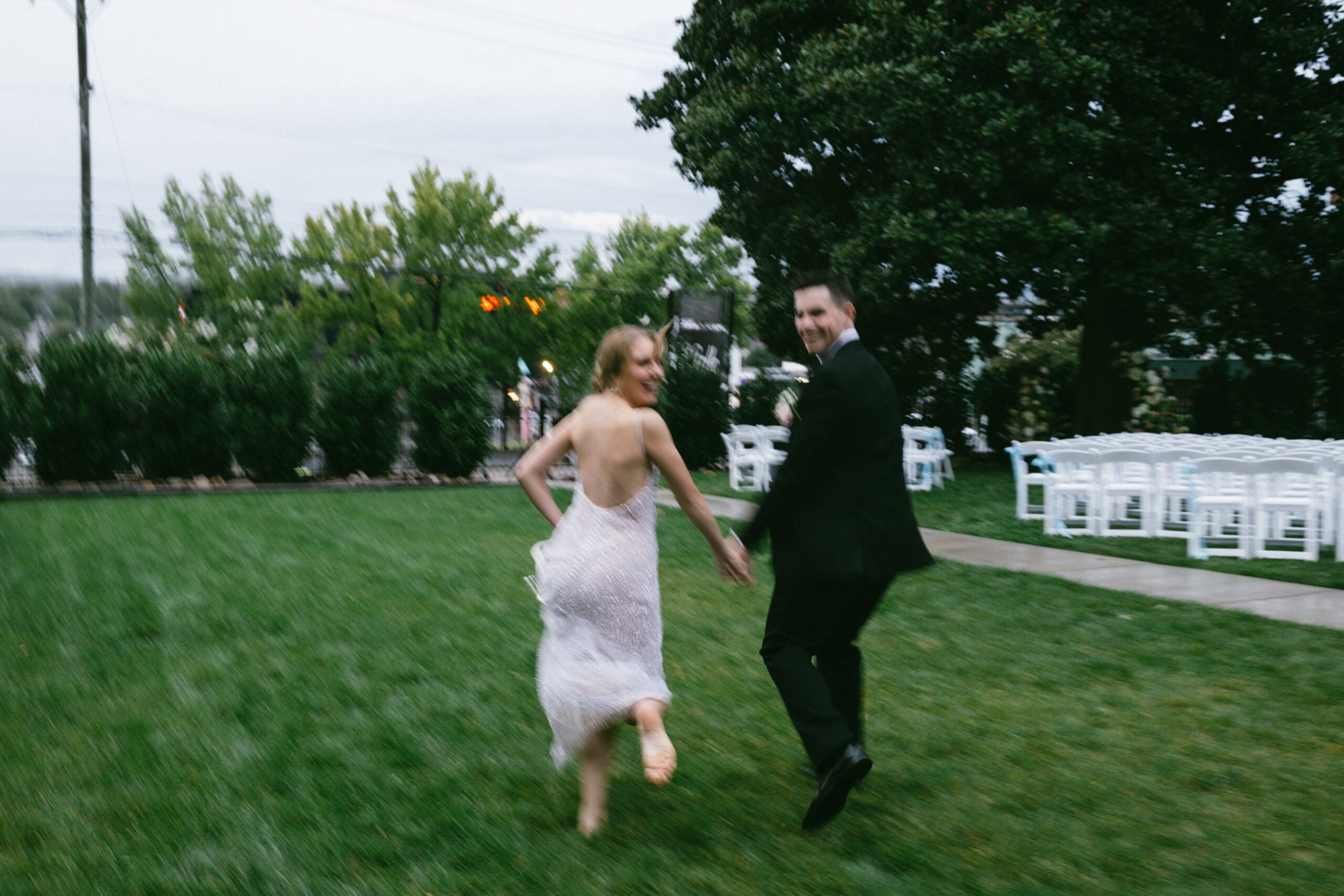 Bride and groom running hand in hand across the lawn after their ceremony at one of the romantic small wedding venues in Nashville TN.