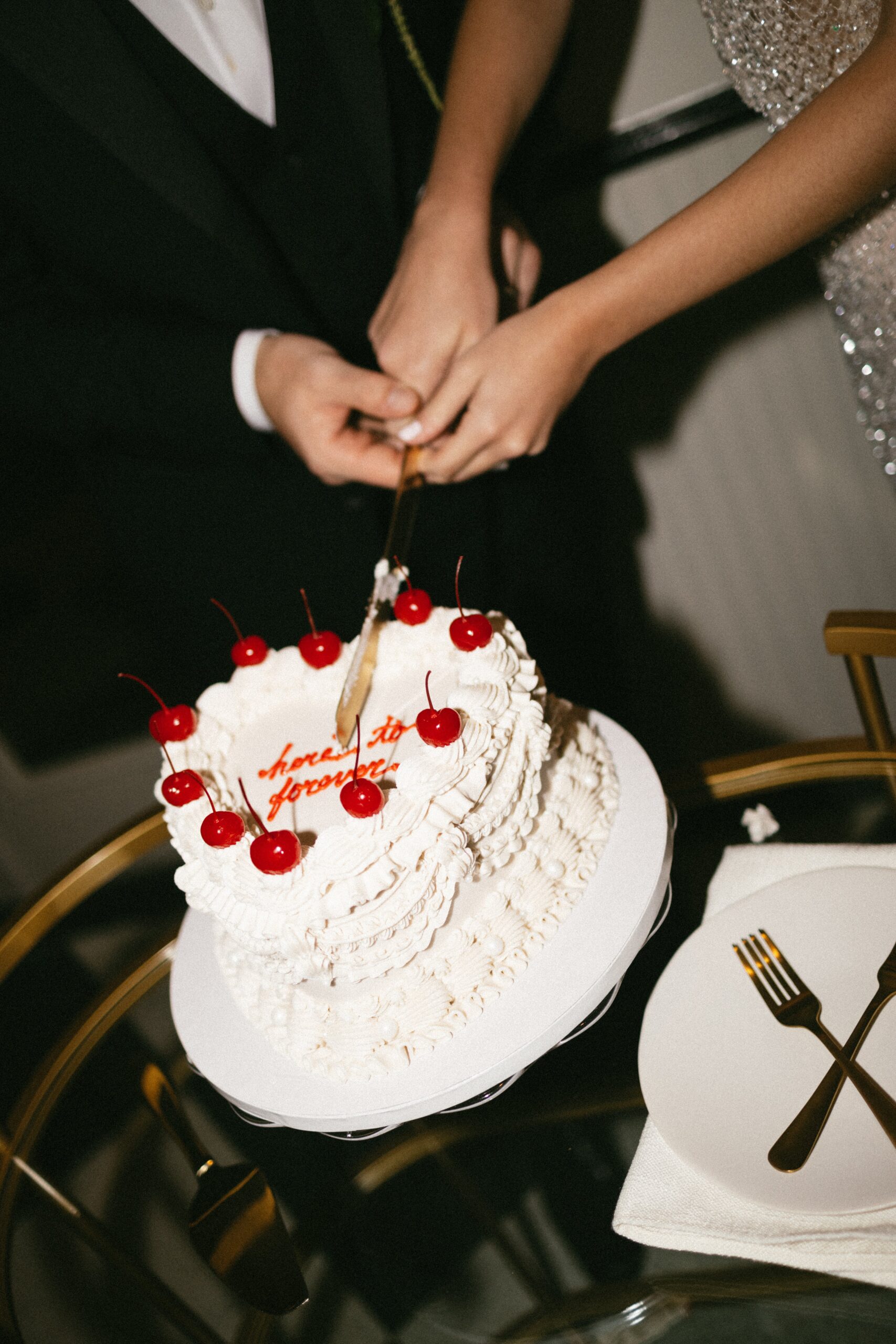 Couple cutting a heart-shaped wedding cake with cherries on top at an intimate celebration in one of the small wedding chapels in Nashville TN.