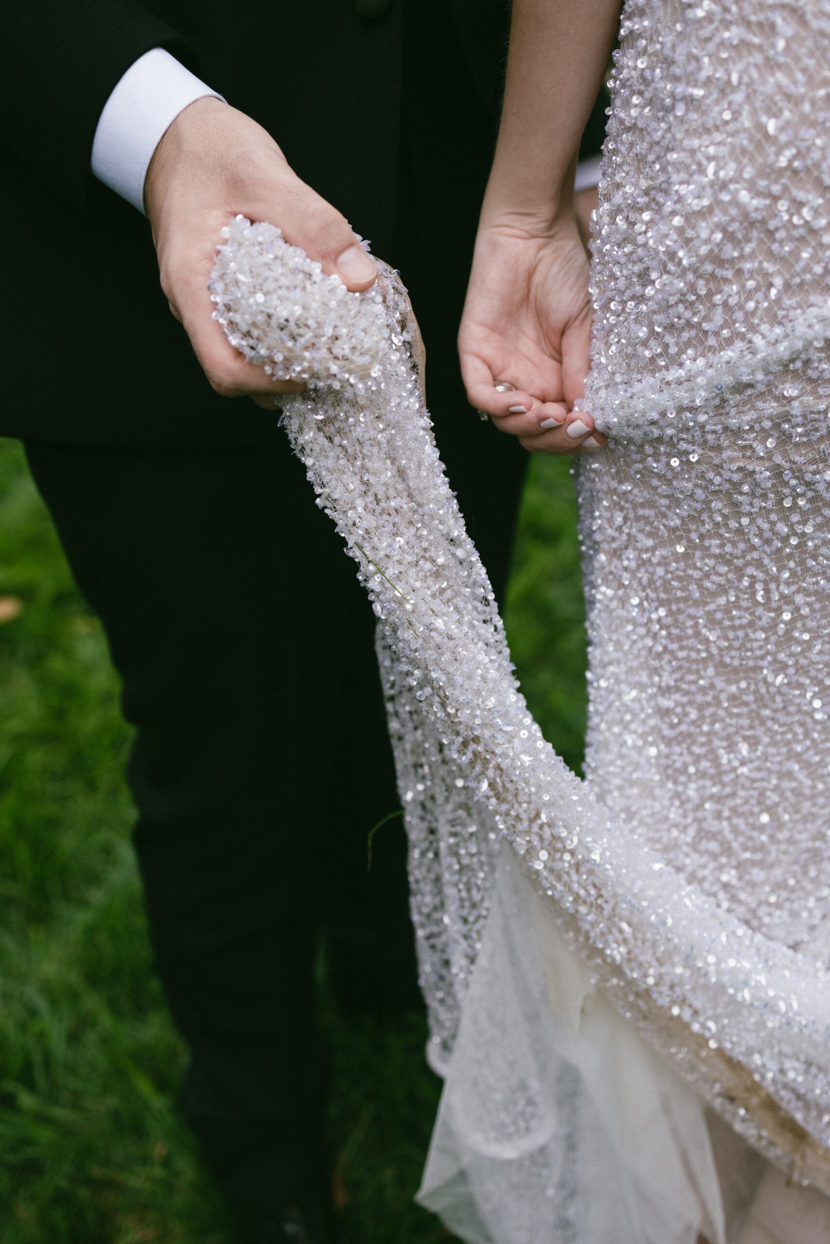 Bride and groom holding the beaded train of a wedding dress during portraits at a romantic small wedding venue in Nashville TN.