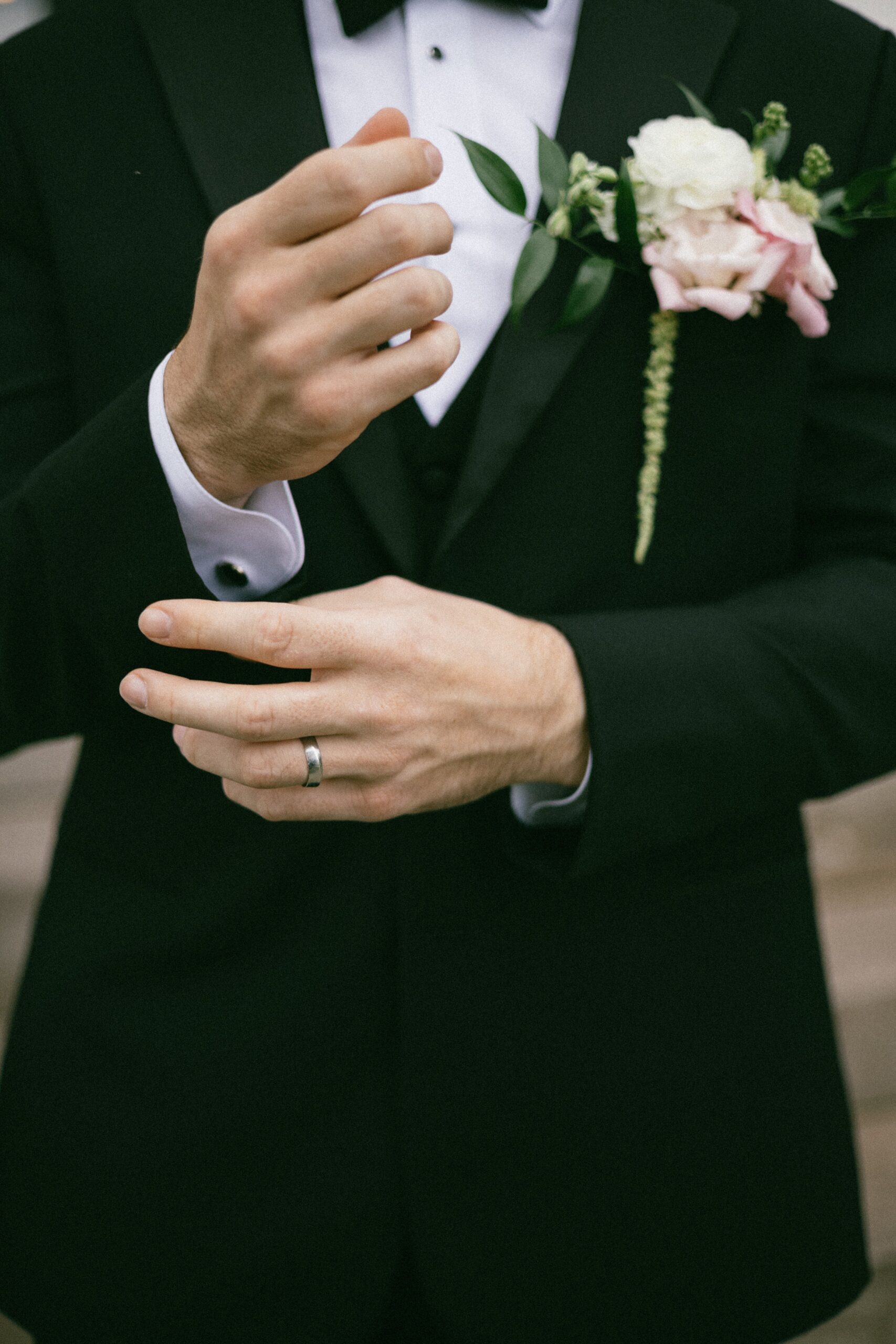 Close-up of groom adjusting his cufflinks and boutonniere before the ceremony at an intimate small wedding chapel in Nashville TN.
