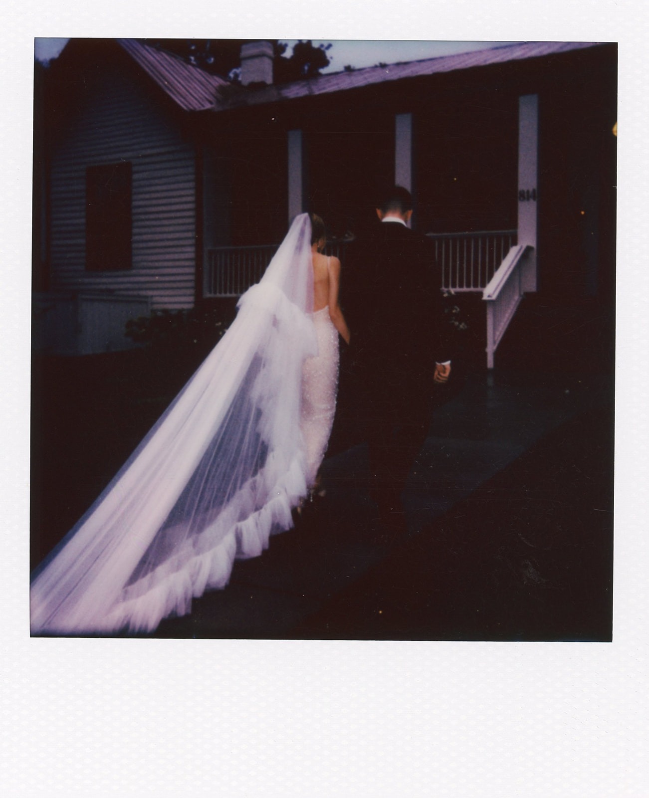 bride and groom walking toward the estelle nashville wedding venue photo in polaroid