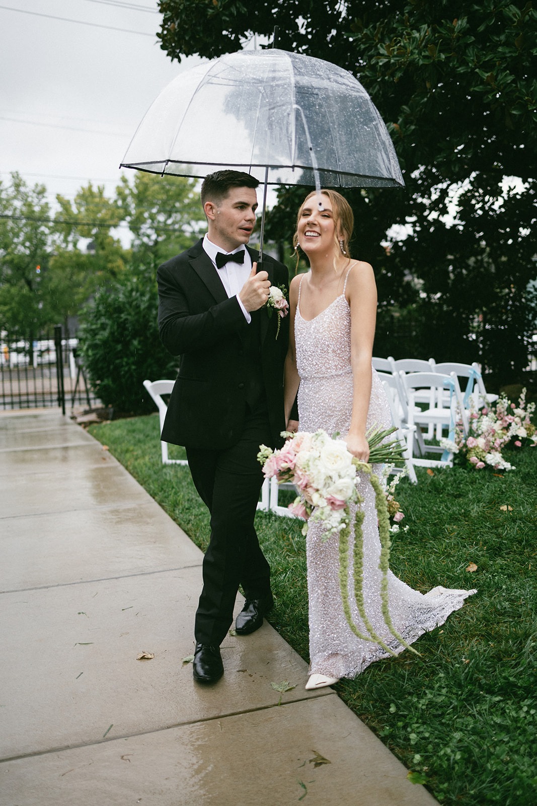 bride and groom walking while it softly rains after their estelle nashville wedding ceremony