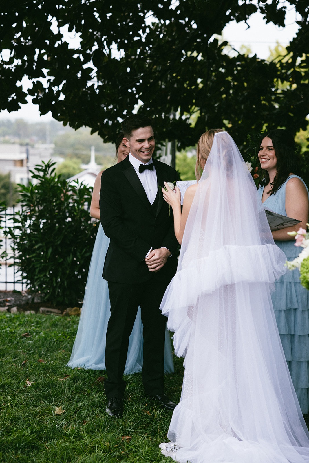 groom smiling while his bride reads her vows during their wedding at the estelle nashville