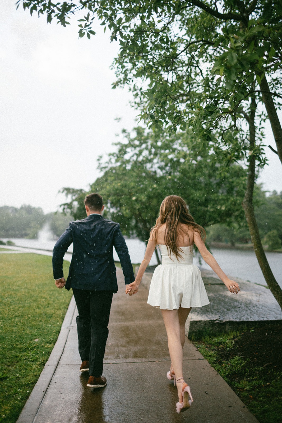 couple walking in the rain during their engagement shoot before getting married at the estelle nashville venue