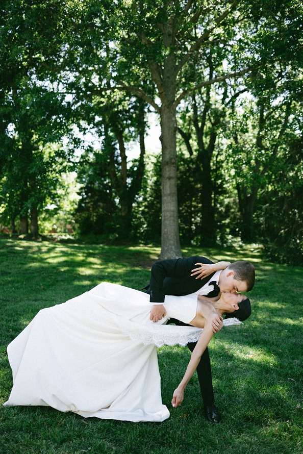 documentary style wedding photography of the groom dipping the bride